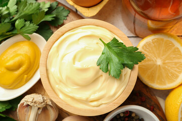 Delicious mayonnaise sauce with parsley, spices and products on table, flat lay