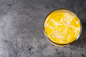 Sweet soda water with ice cubes in glass on grey table, top view. Space for text