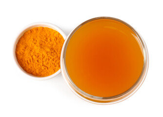 Aromatic turmeric tea in glass and powder isolated on white, top view