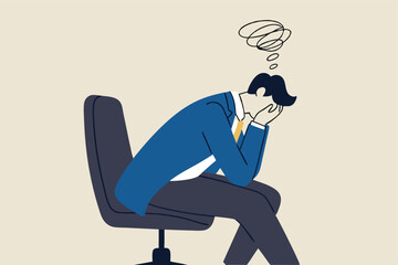 Regret on business mistake, frustration or depressed, stupidity or foolish losing all money, stressed and anxiety on failure concept, frustrated businessman holding his head sitting alone on the chair