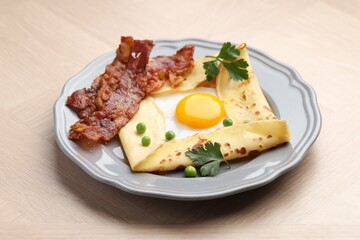 Delicious crepe with egg, bacon and green peas on wooden table. Breton galette
