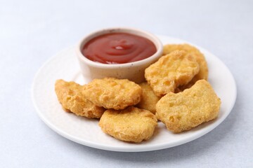 Tasty chicken nuggets with sauce on white background, closeup