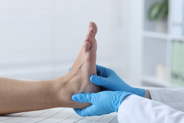 Fototapeta premium Doctor examining patient's foot in hospital, closeup