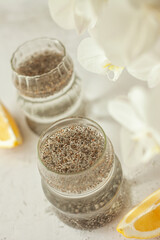 Two glasses of healthy drink to start the day - chia water with lemon on white background, great for hydration, digestion and detox, shot in bright morning light