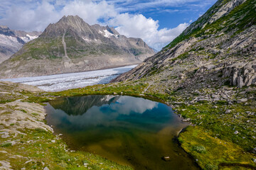 Aerial drone view of Great Aletsch Glacier and Lake In Switzerland Alps in sunny summer day. Popular tourist destination