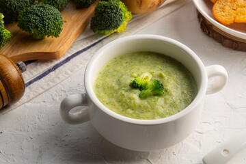 Fresh broccoli soup in white bowl.Cream soup with brocoli potatoes and onion.Healthy vegan dish.
