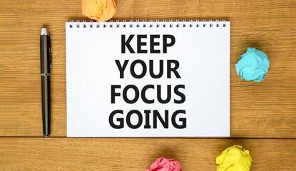 Keep your focus going symbol. Concept words Keep your focus going on beautiful white note. Beautiful wooden background. Black pen. Colored paper. Business and keep your focus going concept. Copy space