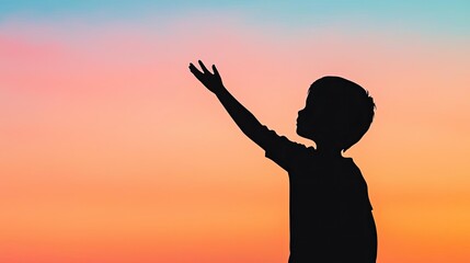 Fototapeta premium Silhouette of a child reaching out against a vibrant sunset background, symbolizing hope and dreams.