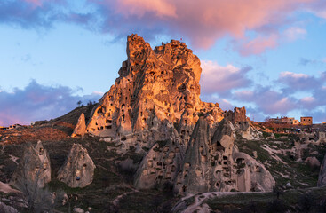 Scenic view of Uchisar Castle at sunset, Central Anatolia, Turkey. Ancient cave dwellings carved in...