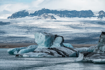 A breathtaking view of Jökulsárlón Glacier Lagoon in Iceland, where massive blue icebergs drift...
