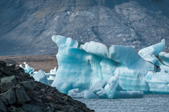 The beautiful Glacier Lagoon Jökulsárlón in Iceland features enormous blue icebergs drifting peacefully on the water, reflecting the Arctic beauty
