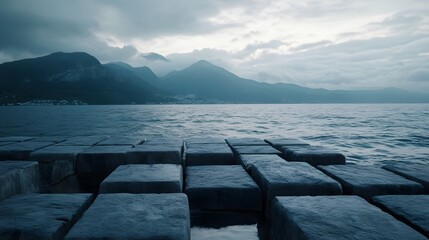 Breathtaking frozen geometric lake landscape at dramatic dusk with a calm reflective surface mirroring the rugged snow capped mountains under an overcast moody sky  A serene