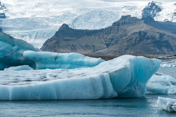 A captivating scene in Iceland’s Jökulsárlón Glacier Lagoon, where bright blue icebergs move...