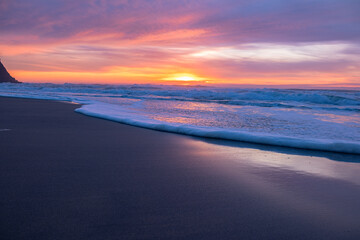 Scenic Sunset Over the Ocean with Waves Washing the Sandy Shore