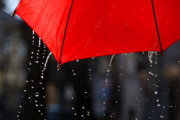 Open red umbrella under pouring rain outdoors, closeup