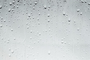 Water drops on light glass surface, top view