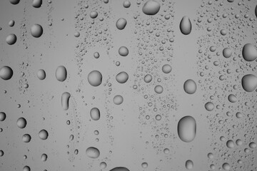 Water drops on grey glass surface, top view