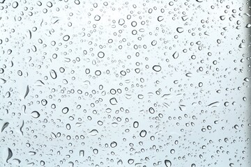 Many water drops on light glass surface, closeup