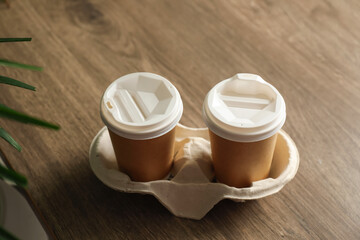 Holder with paper cups on wooden table. Mockup for design