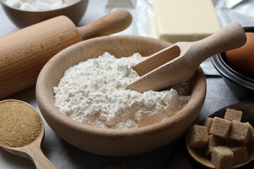 Ingredients for dough and rolling pin on table, closeup