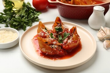 Delicious conchiglie pasta with ricotta cheese, tomato sauce and parsley on white table, closeup
