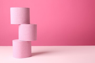 Color toilet paper rolls on pink background. Space for text