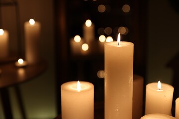 Many burning candles on blurred background, closeup