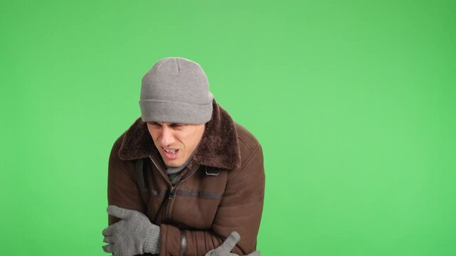 Man shivering and freezing on green screen background