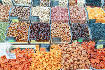 Various tasty and healthy dried fruits and nuts lie in boxes on the market counter.