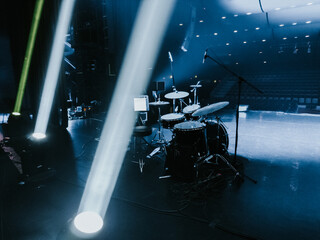 A close-up of a green spotlight casting a bright beam in a dimly lit concert or event venue. The...