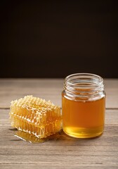 Honeycomb and Honey in a Jar on Wooden Table