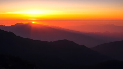 Fototapeta premium a breathtaking view of the sunset over a mountain range, casting long shadows 