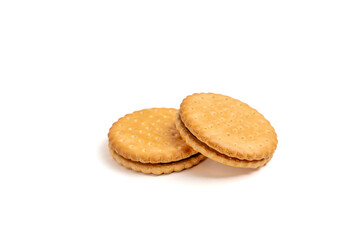 Two cookies with a chocolate filling. They are sitting on a white background. The cookies are round and have a hole in the middle