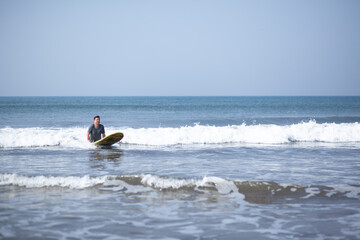A man on a vacation surfs on a board in the ocean
