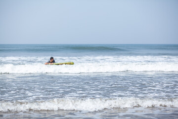 A man on a vacation surfs on a board in the ocean