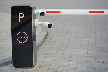 Two digital security cameras installed at a restricted parking entrance for vehicle surveillance...