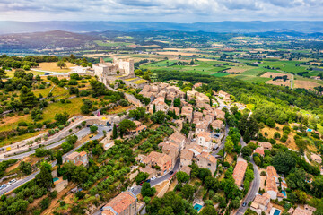 Fototapeta premium View of the old town of Lacoste, ancient village in France, Vaucluse, Provence-Alpes-Cote d'Azur, Park of Luberon. Lacoste village picturesque countryside of France surrounded by lush green hills.