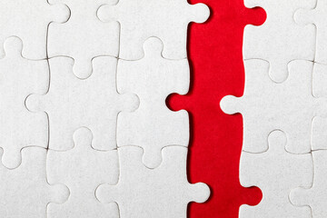 Fototapeta premium White jigsaw puzzle. White puzzle pieces on color background. Unfinished white jigsaw puzzle pieces on color background.