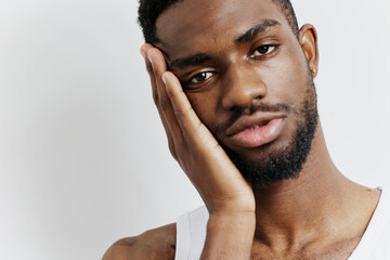 Pensive african american man in tank top reflects deeply with hand on face in thoughtful moment