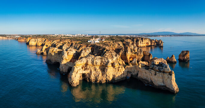 Panoramic view, Ponta da Piedade near Lagos in Algarve, Portugal. Cliff rocks and tourist boat on sea at Ponta da Piedade, Algarve region, Portugal. Ponta da Piedade, Algarve region, Portugal.