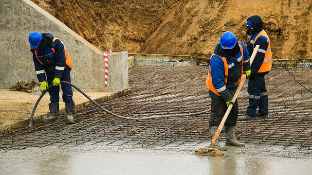 Workers are pouring structural concrete at a construction site
