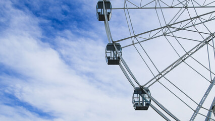 Obraz premium A majestic Ferris wheel stands tall against a clear blue summer sky