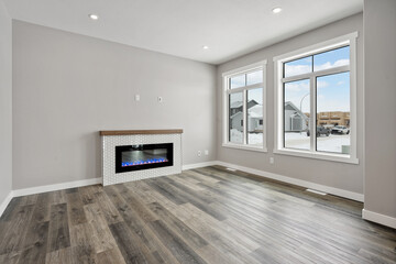 Large living room with a fireplace and two windows