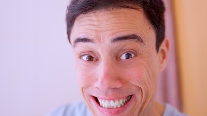 Man making funny face with wide eyes and smiling