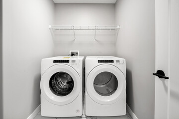 White washer and dryer are in a small, white room