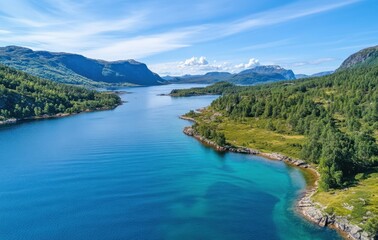 Naklejka premium Breathtaking aerial view of serene lake surrounded by lush forests and majestic mountains under bright blue sky in a tranquil natural landscape