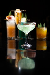Various alcoholic cocktails on a black background.