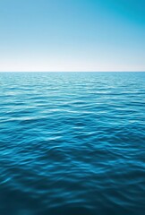 Obraz premium Calm Blue Ocean Waves Under a Clear Sky Reflecting Serenity and Peacefulness in a Tranquil Seascape Ideal for Vacation and Relaxation Themes