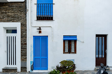 facade of a residential building with white walls, doors and window with blue shutters