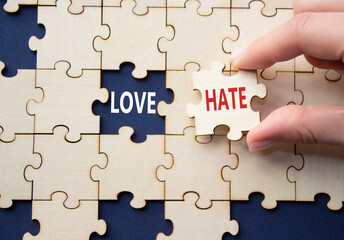 Love vs Hate symbol. Concept word Love vs Hate on wooden puzzle. Businessman hand. Beautiful deep blue background. Business and Love vs Hate concept. Copy space